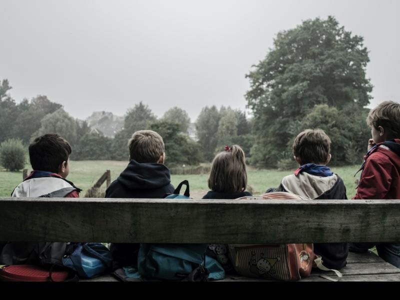 children sitting on a park bench