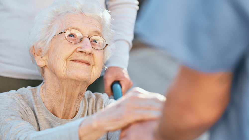 elderly person holding hands with caregiver