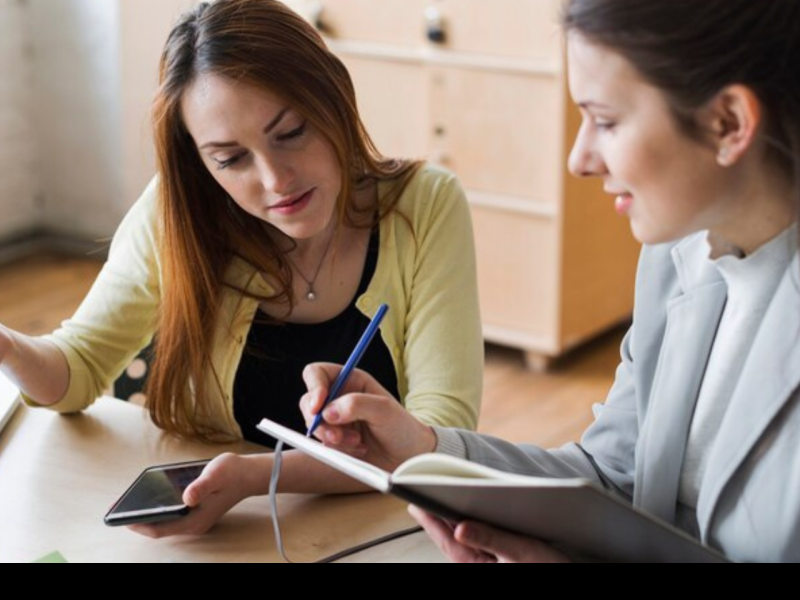 two women reviewing notes